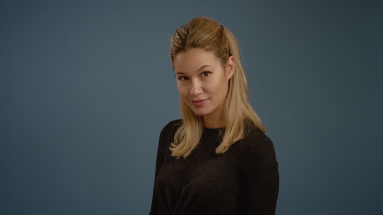 mujer joven se vuelve hacia la cámara y sonríe