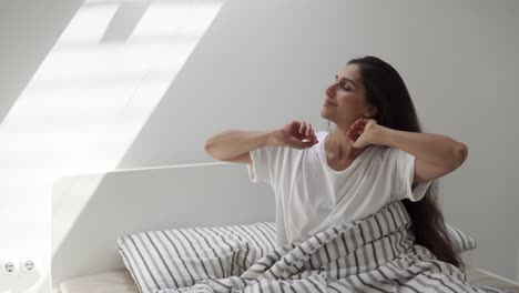 mujer estirándose en la cama