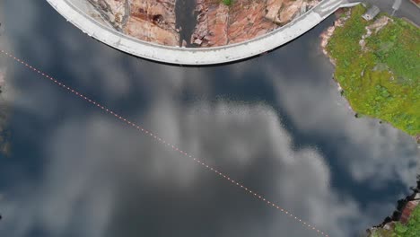 clouds and sky reflecting on waters of sarvsfossen dam in bykle, norway