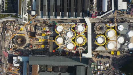 Aerial-top-down-view-of-huge-construction-site-of-main-train-station-Stuttgart-S21-with-cranes-and-construction-worker-descending-in-Stuttgart,-Germany