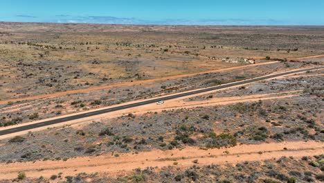 drone view of barren landscape with an asphalt road stretching across in exmounth, australia.