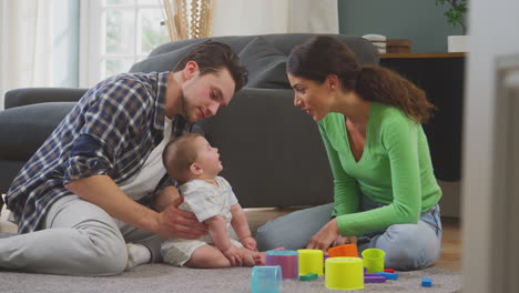 Transgender-Family-With-Baby-Playing-Game-With-Colourful-Toys-In-Lounge-At-Home