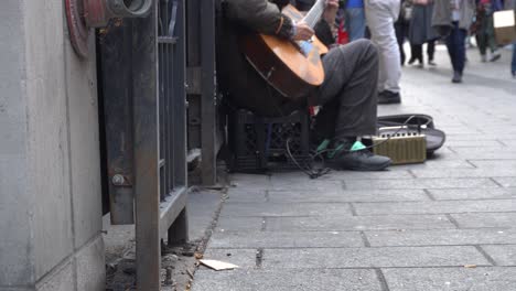 someone playing guitar in the street and the hope to make some money