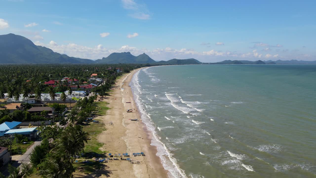Metraje inverso tomado desde una altitud mayor revelando la imagen completa de una playa y un paisaje tan encantadores.