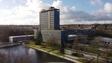 Aerial-view-Pilkington's-glass-head-office,-a-modern-blue-high-rise-with-shared-office-space,-dolly-right