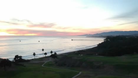 view of the golf course and ocean with vibrant sunset