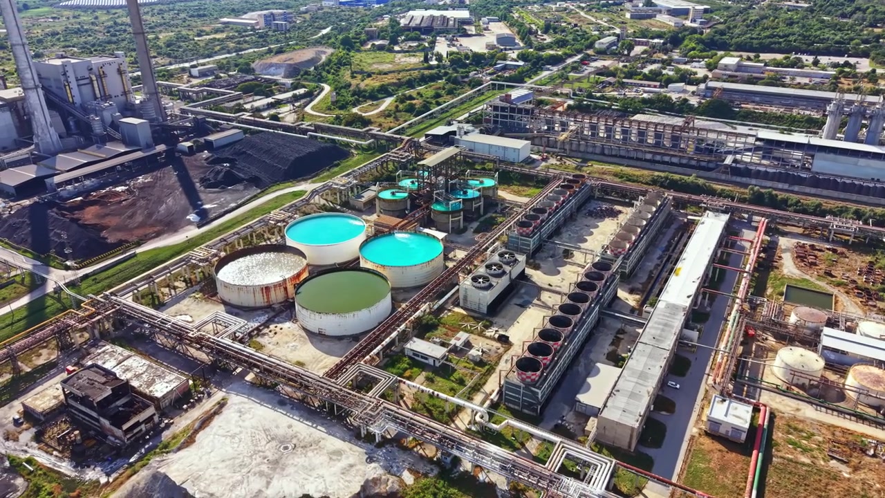Industrial site with large tanks and processing facilities in a rural area during daytime