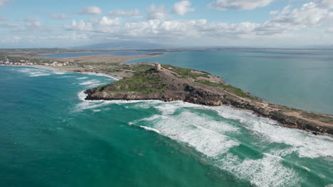 Torre-di-San-Giovanni-di-Sinis,-Sardinia:-fantastic-aerial-view-over-the-famous-tower-and-overlooking-a-spectacular-coastline-with-turquoise-waters