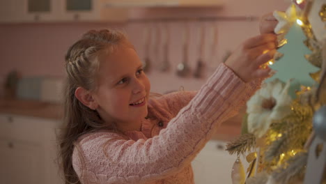 Niña-Decora-El-árbol-De-Navidad-Con-Adornos-En-Casa