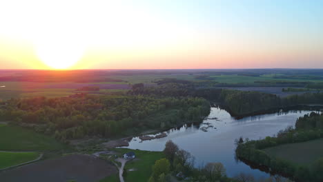 Wunderschöner-See,-Umgeben-Von-Vegetation-Unter-Einem-Goldenen-Himmel-Bei-Sonnenuntergang