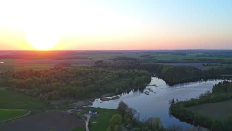 Hermoso-Lago-Rodeado-De-Vegetación-Bajo-Un-Cielo-Dorado-Al-Atardecer