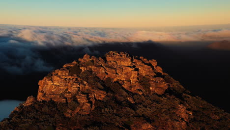 Vista-Aérea-Alrededor-De-La-Gente,-En-La-Cima-De-La-Montaña-Del-Monte-Hassell,-Por-Encima-De-Las-Nubes,-Durante-La-Puesta-De-Sol,-En-El-Oeste-De-Australia---órbita,-Disparo-De-Drones