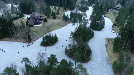 people ice skating frozen lake in europe, drone view