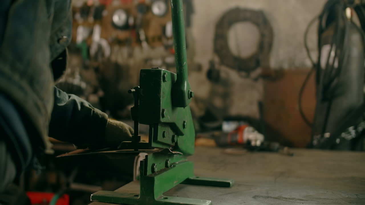 Metalworker using a shearing machine in a workshop