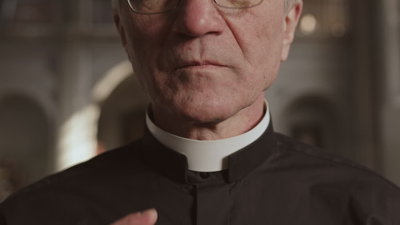 Aged Priest Fixing White Collar on His Neck