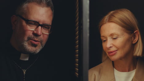 female penitent and priest talking in private during confession
