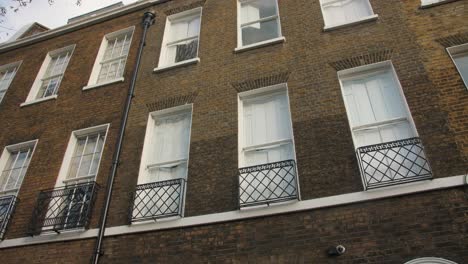 tilt-down reveal of red door entrance of charles dickens museum in a typical georgian house along doughty street, king's cross in london borough of camden