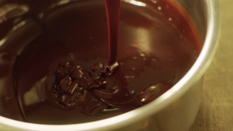 mixing chocolate with spatula in slow motion. closeup chocolate stream.