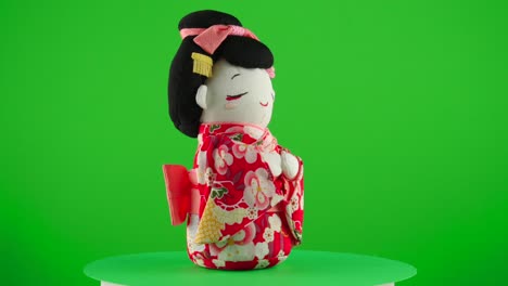 red kimono with sakura maiko geisha doll handmade handcraft japan traditional gift present in a turntable with green screen for background removal