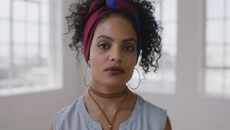 close up portrait of young stylish hispanic woman looking intense serious at camera independent female beauty