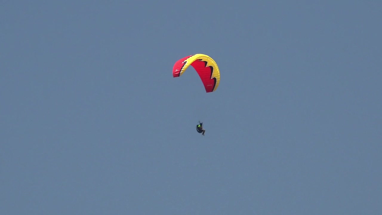 Paraglider svever gjennom klar blå himmel