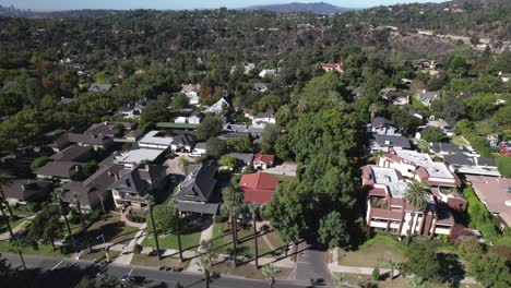 aerial view flying over american residential neighborhood homes in lush green suburbs of pasadena, california
