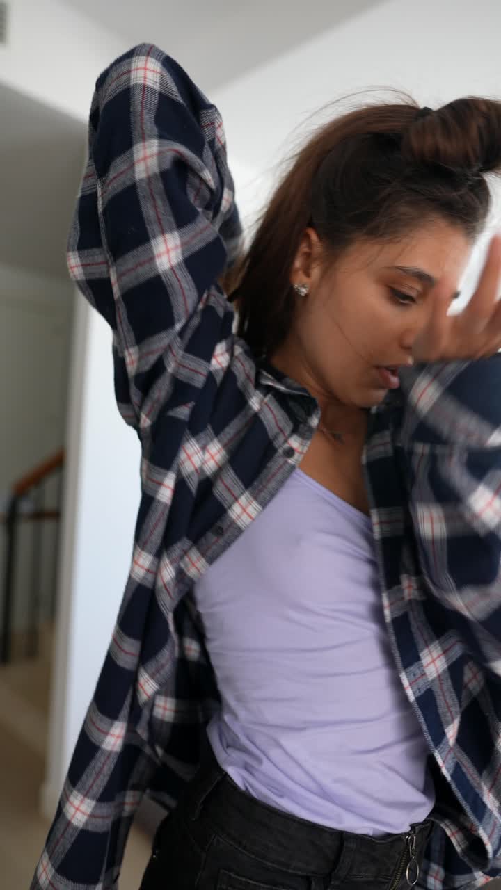 una mujer joven bailando en casa.