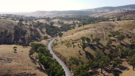 Aerial-drone-view-of-scenic-landscape-mountains-hill-freeway-with-car-and-bushland-trees-Flinders-Ranges-Port-Augusta-Adelaide-South-Australia-4K