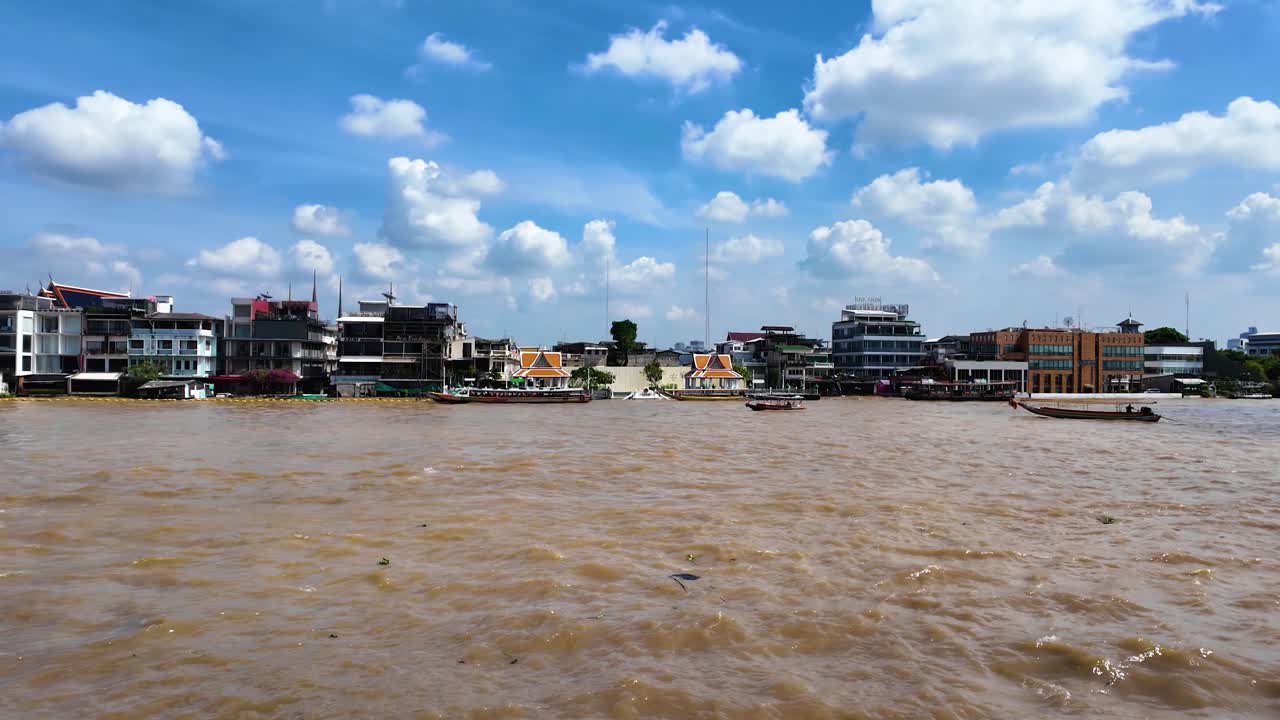 Boats glide on Chao Phraya River in sunny Bangkok, vibrant and lively