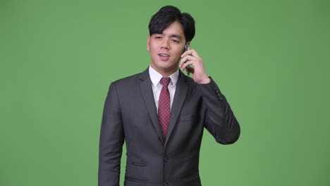 young handsome asian businessman using mobile phone