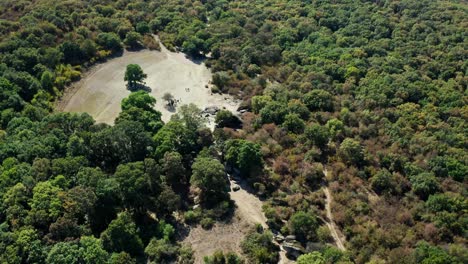 Orbiting-drone-shot-of-the-Thracian-sanctuary-Beglik-Tash,-a-natural-landmark-surrounded-by-lush-green-forest,-bordering-the-Black-Sea,-at-the-foot-of-Strandzha-Mountain-in-Bulgaria