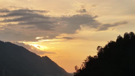 Beautiful-sunset-over-silhouetted-mountains-and-trees-in-Glarus-Nord,-Switzerland