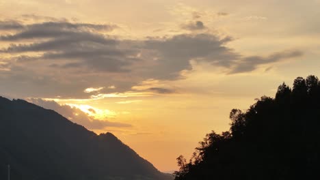 hermosa puesta de sol sobre las siluetas de las montañas y los árboles en glarus nord, suiza