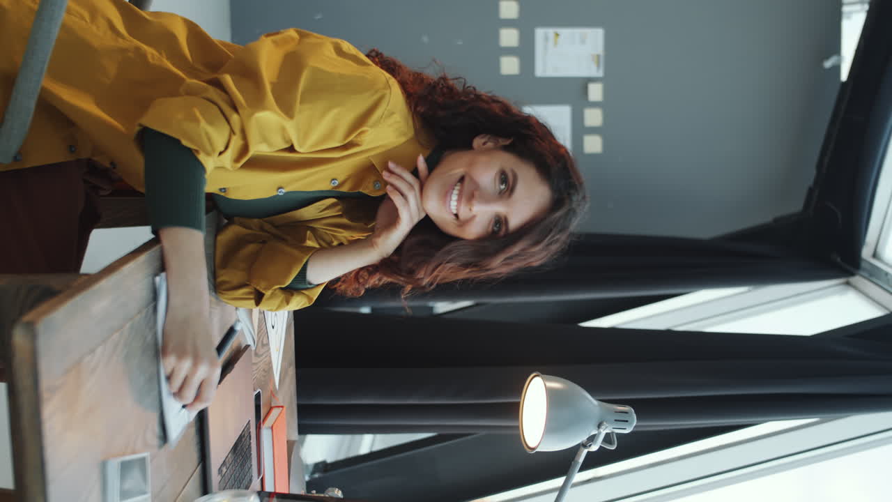 Donna d'affari allegra alla scrivania in un ufficio panoramico