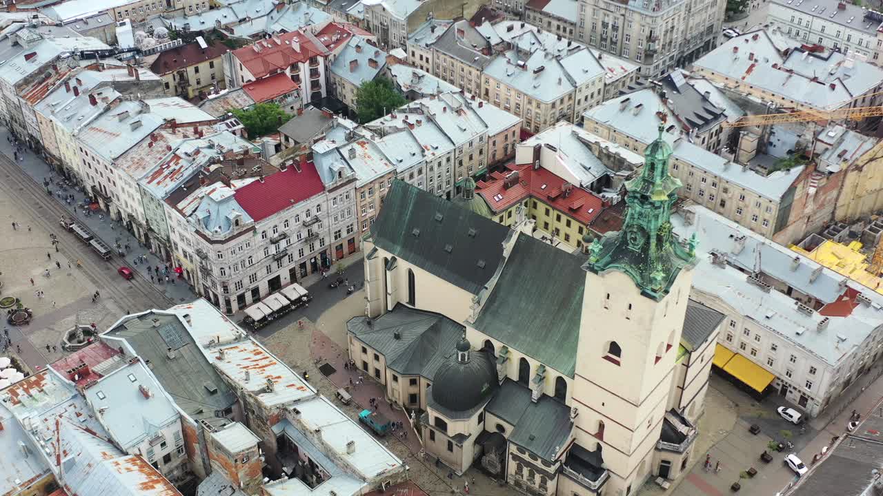 Drone aéreo de uma igreja com campanário perto da Praça Rynok em Lviv, Ucrânia, rodeada por antigos edifícios históricos europeus