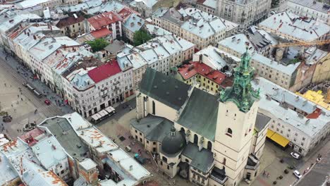 aerial drone of a church with a bell tower near rynok square in lviv ukraine surrounded by old historical european buildings