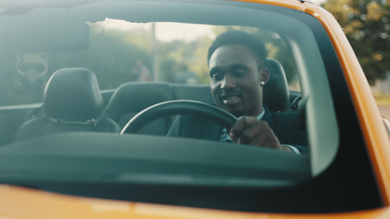 컨버터블 자동차를 운전하는 남자