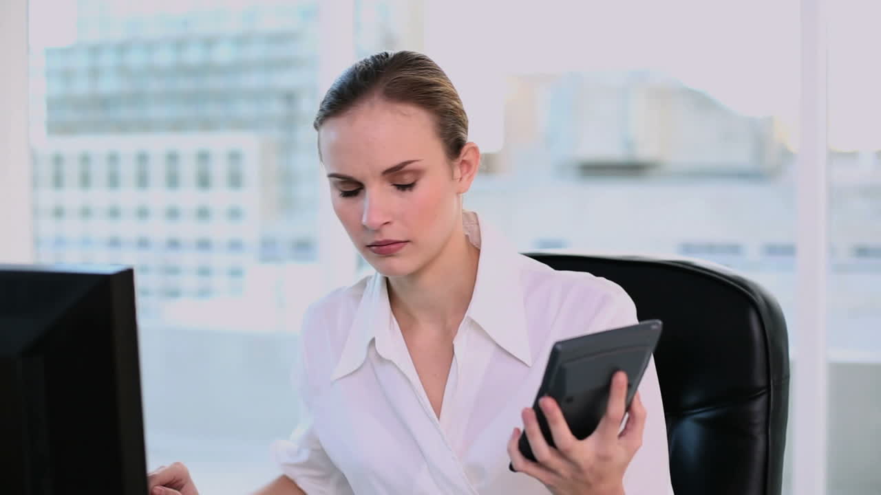 una mujer de negocios estresada haciendo cálculos.