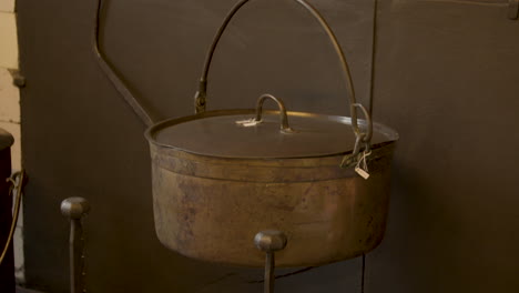 close tilt up over old pan hanging above wood in old fashioned kitchen