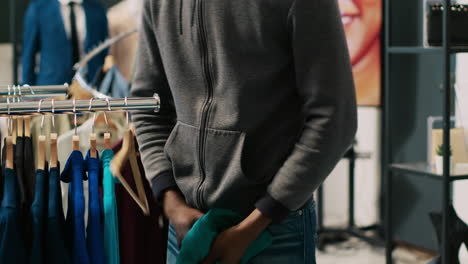 thief trying to stole fashionable shirt