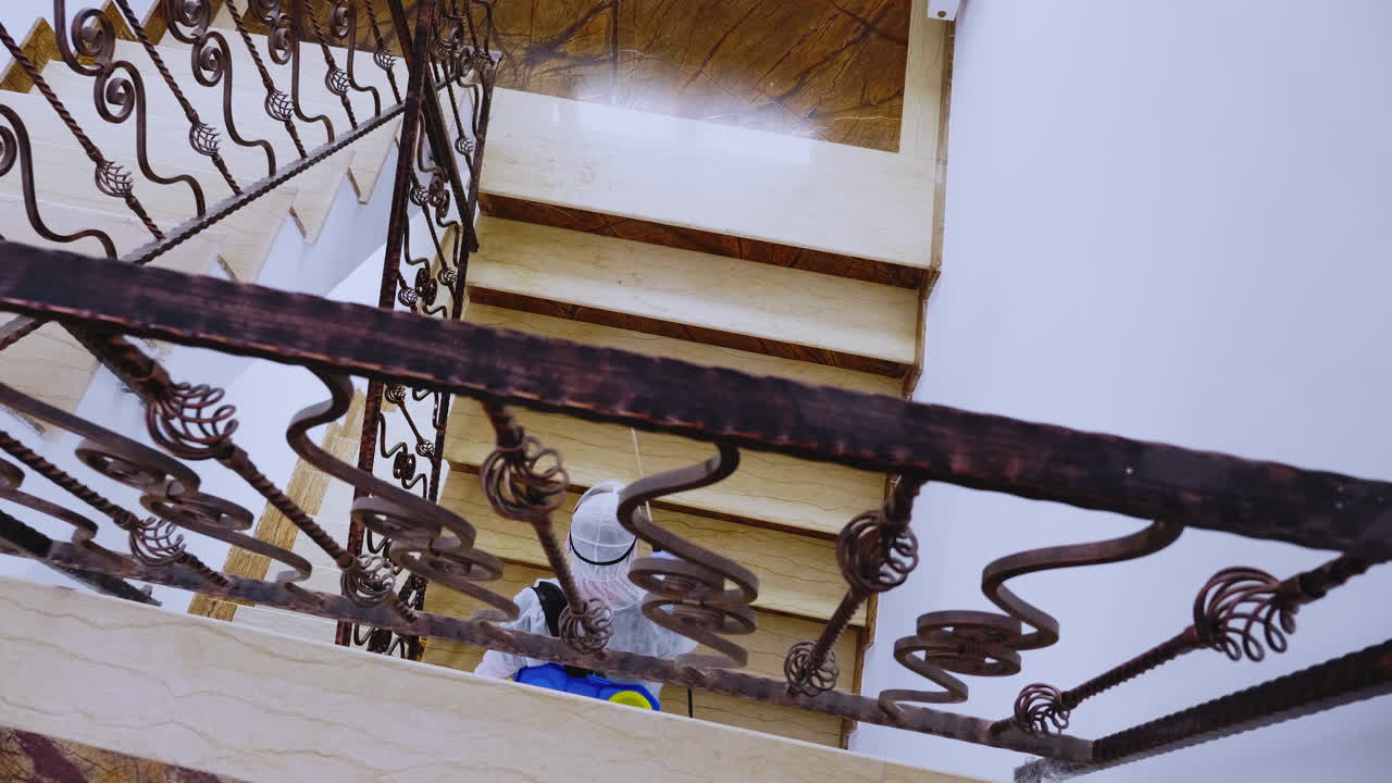 해즈마트 슈트를 입은 노동자가 소독제를 뿌리고 있습니다.