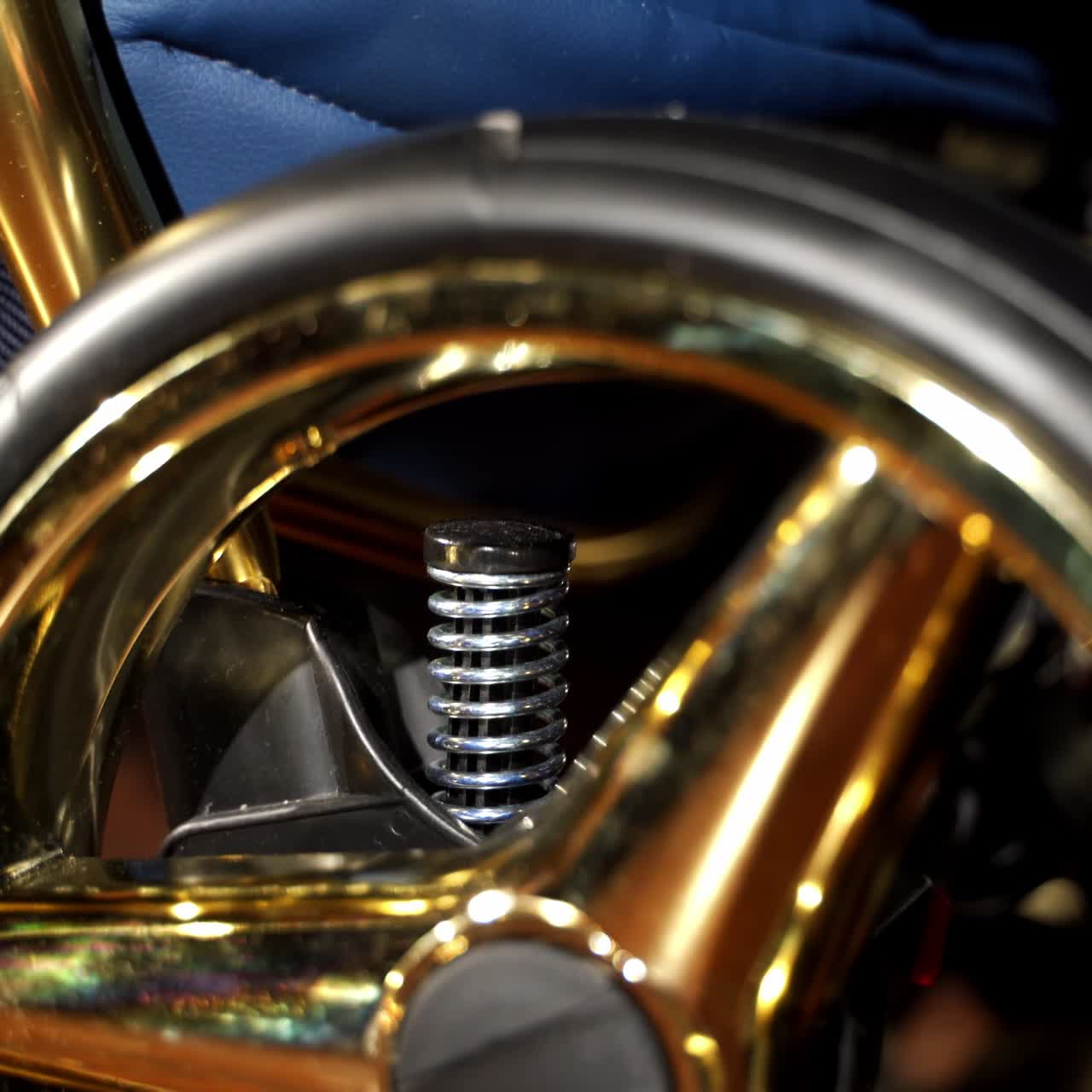 Fashionable new baby stroller for walks outside. Wheel of a perambulator with golden details and spring behind. Close up