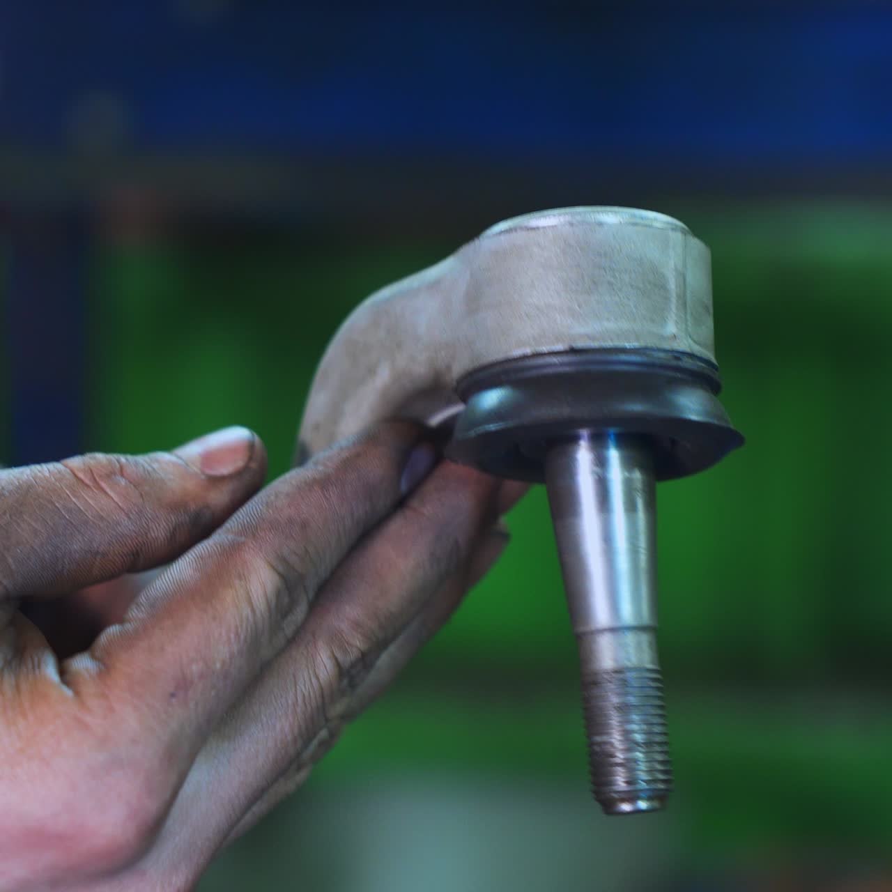 Turner's dirty hands holding a piece of detail. He's turning it and checking. Close up. Blurred background