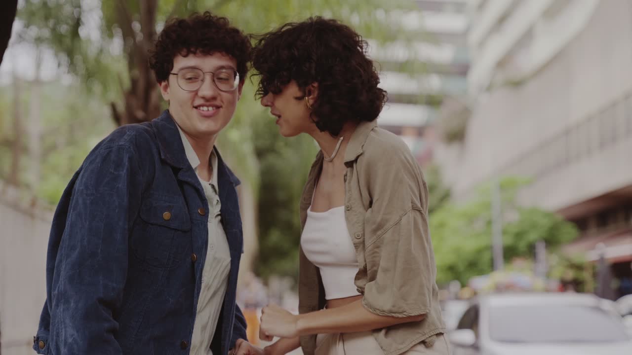Two young people having a friendly conversation on a city street