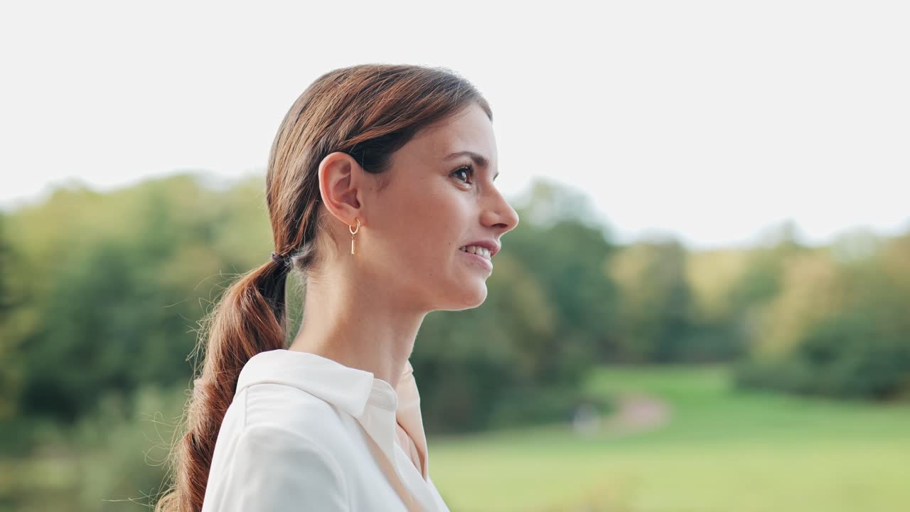 A businesswoman stands outside and listens to her colleagues' conversation