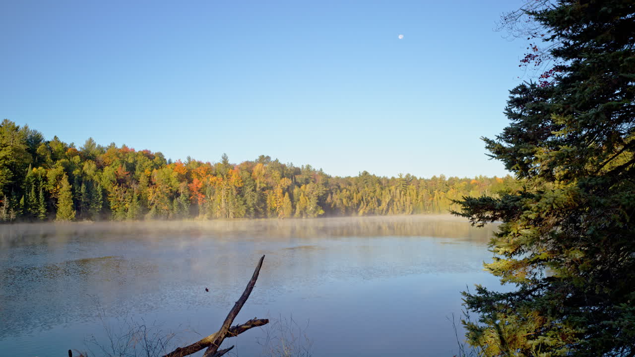 Cinematic scenic river shot with fog rising at sunrise