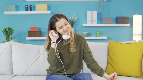 una chica joven escuchando música divertida está bailando y sintiéndose feliz.
