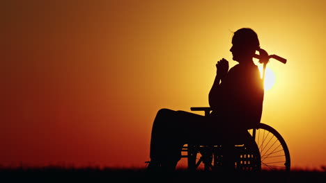 sunset silhouette of person in wheelchair