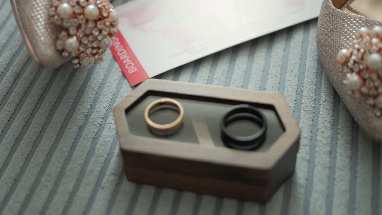 Pair of beautiful wedding rings for the Groom and Bride, with bridal shoes in the background