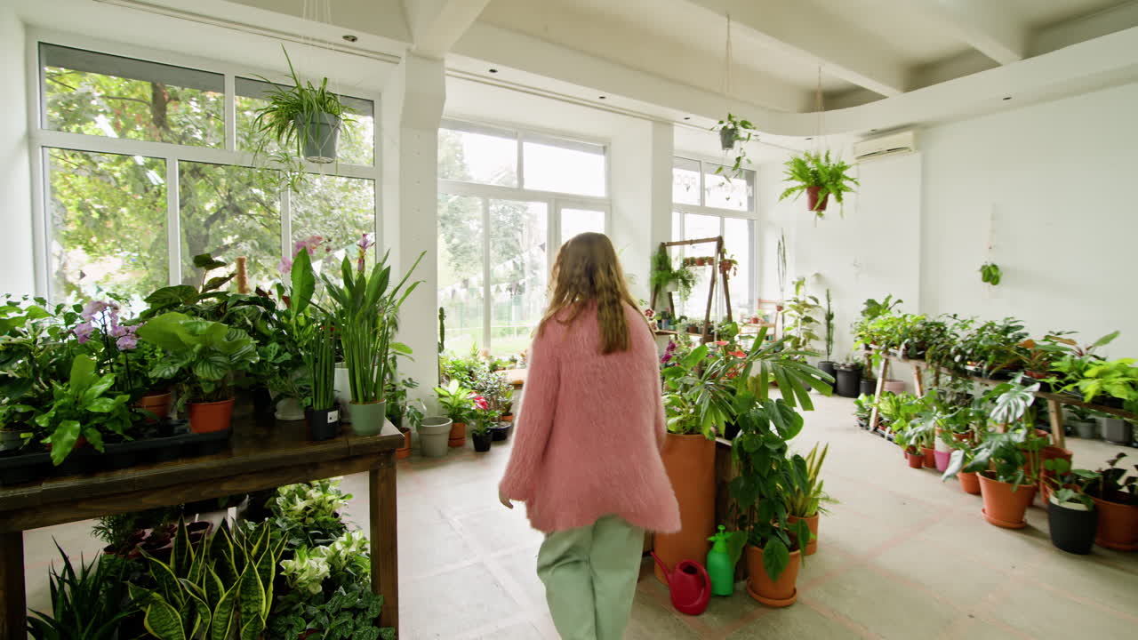 женщина покупает растения в ботаническом магазине.